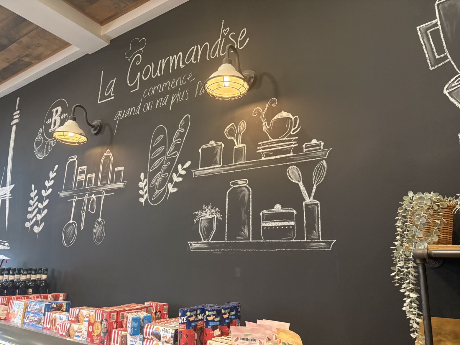 Mur d'ardoise illustré à la craie : « La Gourmandise commence quand on n'a plus faim »